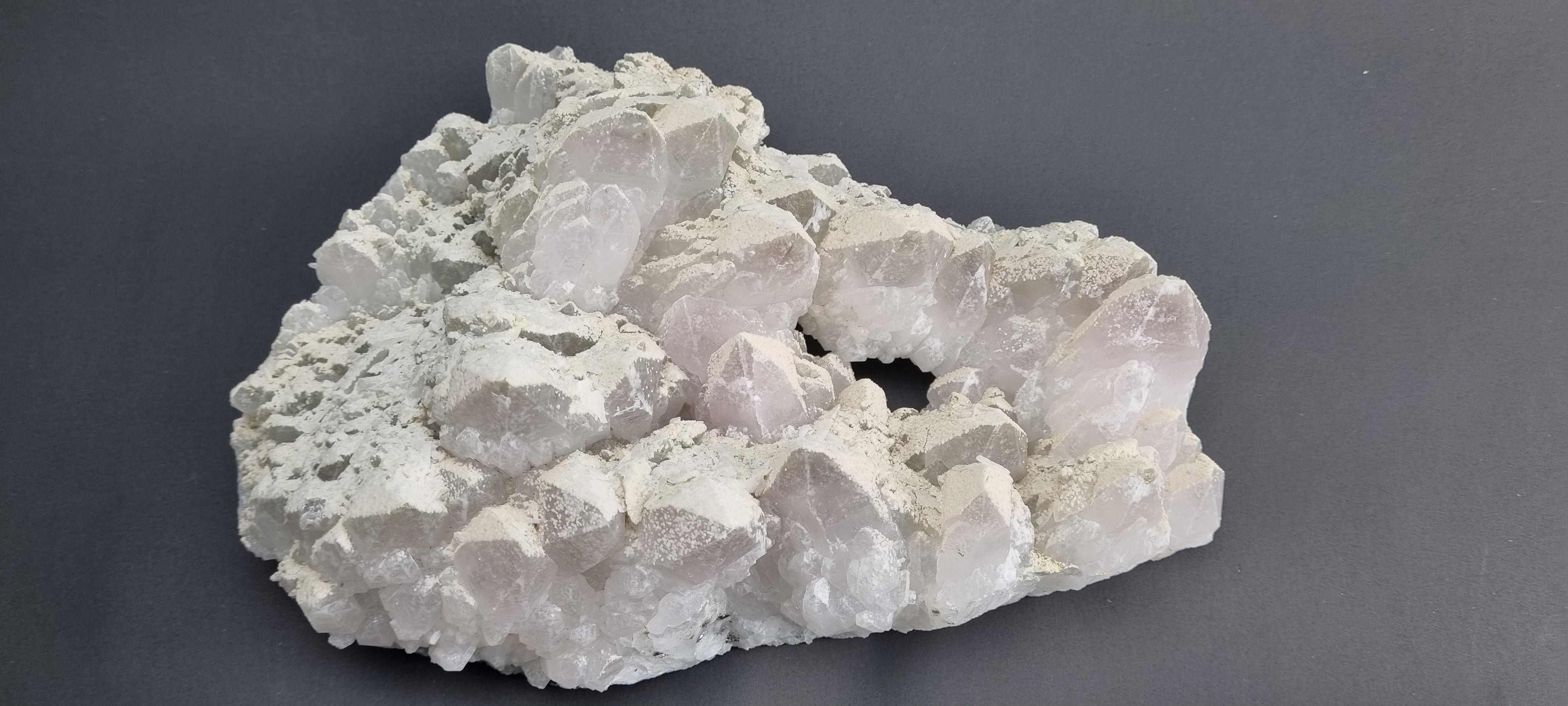 Quartz crystal cluster with a preferential dusting of Calcite and minor Pyrite on matrix