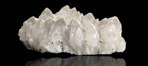 Quartz crystal cluster with a preferential dusting of Calcite and minor Pyrite on matrix