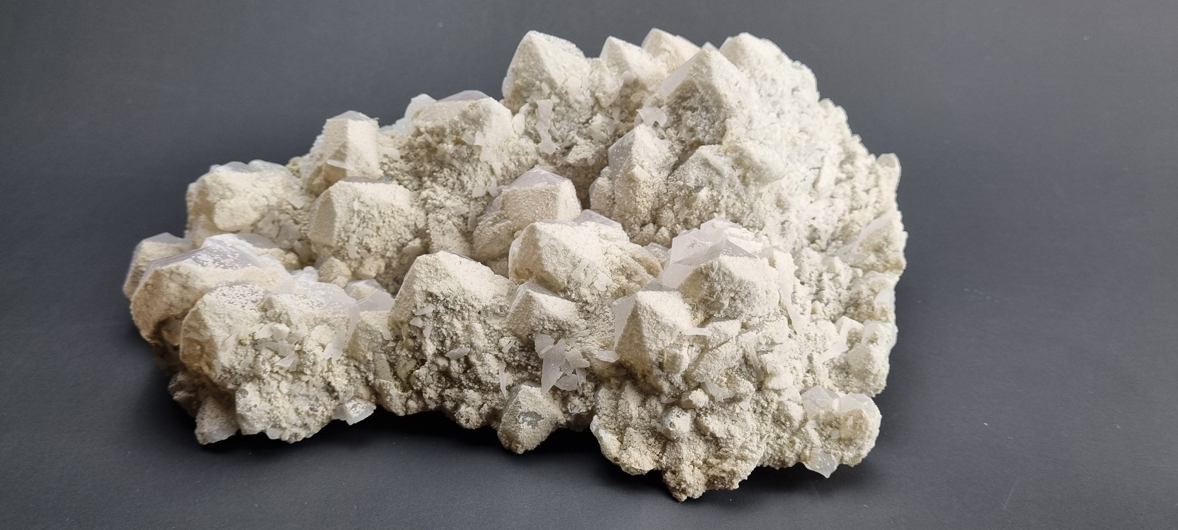 Quartz crystal cluster with a preferential dusting of Calcite and minor Pyrite on matrix