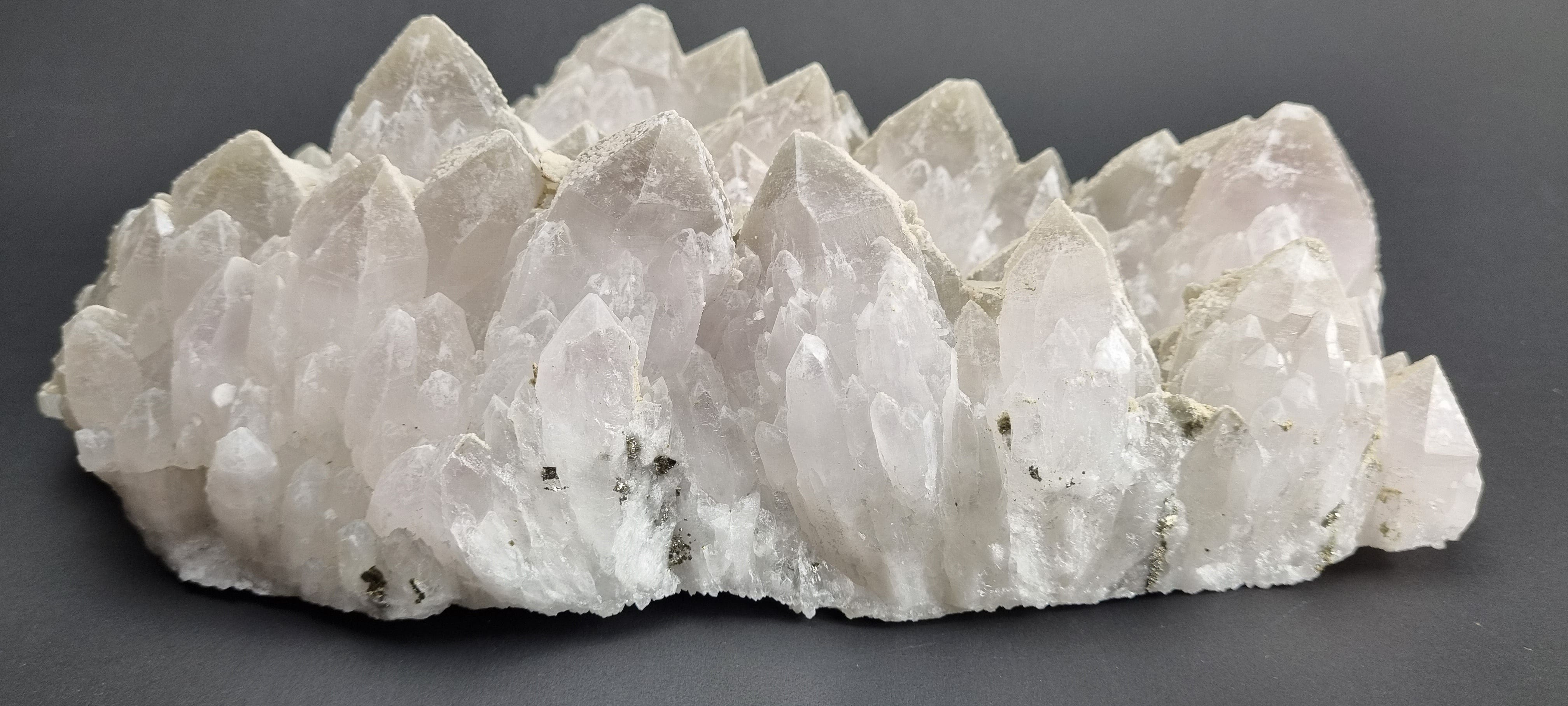 Quartz crystal cluster with a preferential dusting of Calcite and minor Pyrite on matrix