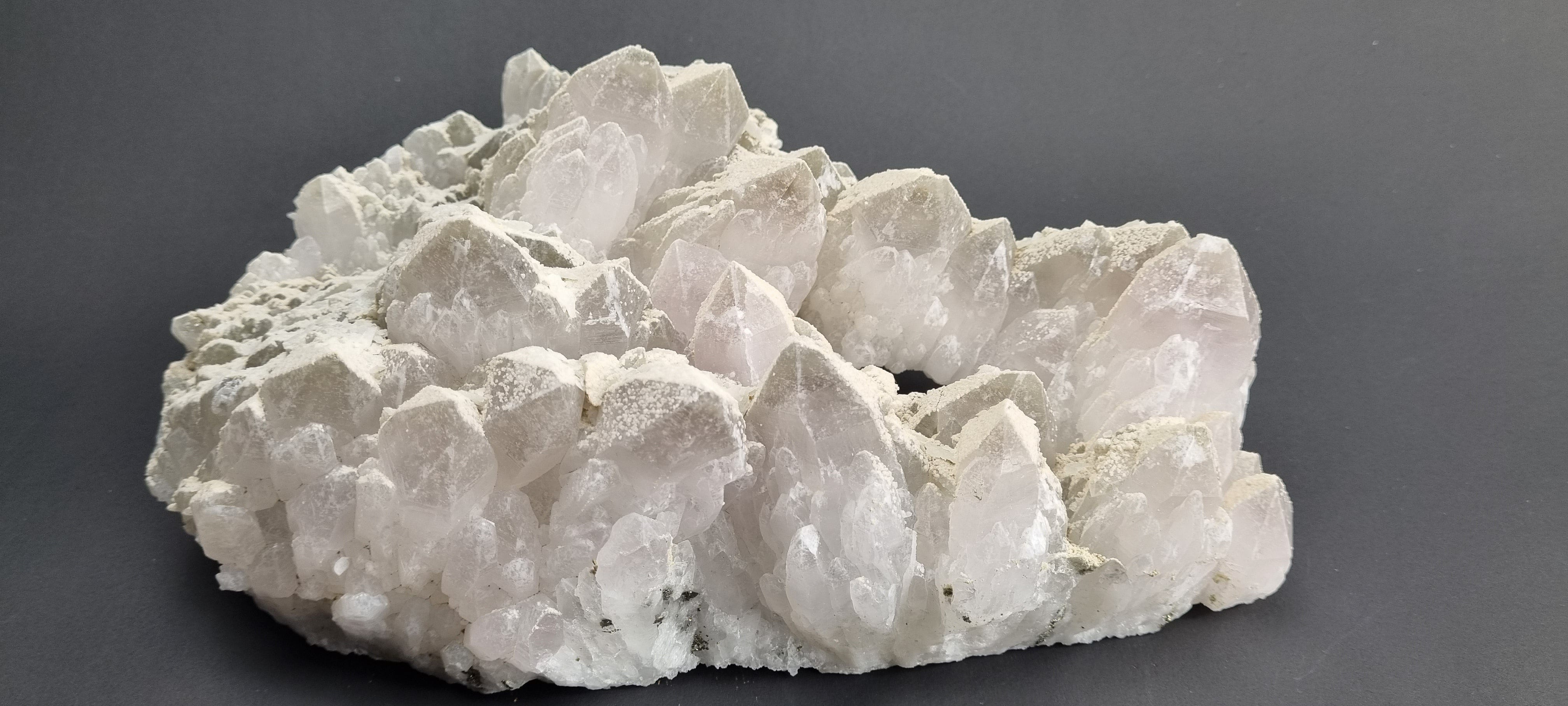 Quartz crystal cluster with a preferential dusting of Calcite and minor Pyrite on matrix